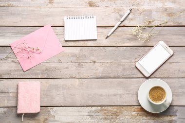 Defterlerden, zarftan, cep telefonundan ve yıpranmış ahşap masada bir fincan kahveden yapılmış çerçeve.