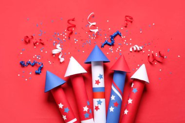 Kırmızı zemin üzerinde Bağımsızlık Günü için havai fişek, yılan ve konfeti