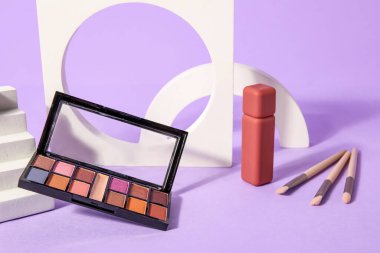 Leylak arkaplan üzerinde ruj, fırça ve podyum sürmüş göz farı