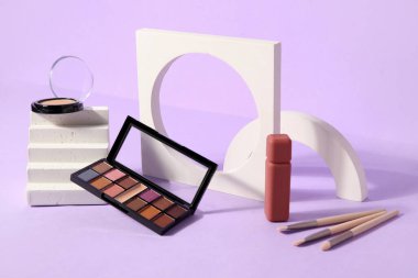 Leylak arkaplan üzerinde ruj, fırça ve podyum sürmüş göz farı