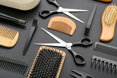 Siyah arka planda kuaför aksesuarları olan kompozisyon, yakın plan.