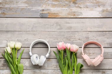 Modern kulaklıklı kompozisyon ve ahşap arka planda güzel lale çiçekleri.