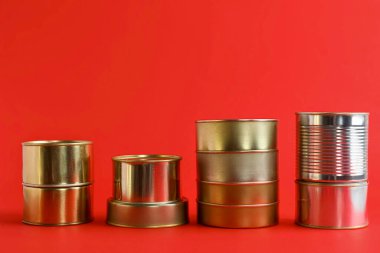 Kırmızı arka planda balık dolu teneke kutular.