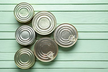 Yeşil ahşap masadaki balıklı teneke kutular.