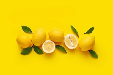 Composition with fresh lemons on yellow background