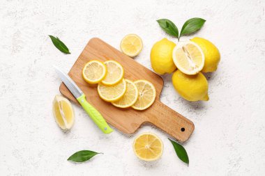Beyaz arka planda taze limonları olan tahta