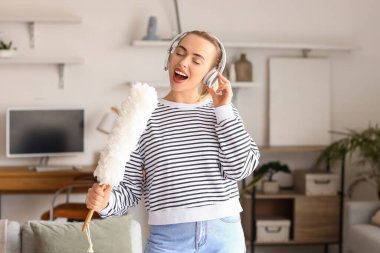 Genç bir kadın evde şarkı söylüyor.