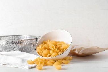 Hafif ahşap zemin üzerinde çiğ koni makarna ile kase