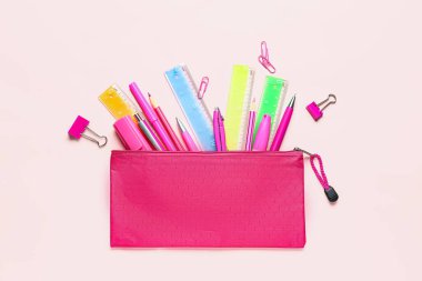 Pembe arka planda renkli kırtasiye malzemeleri
