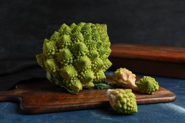 Mavi grunge masasında Romanesco lahanası olan ahşap tahta tahta.