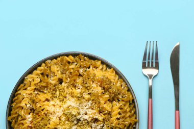 Mavi arka planda parmesan peynirli lezzetli İtalyan makarnası, yakın plan.