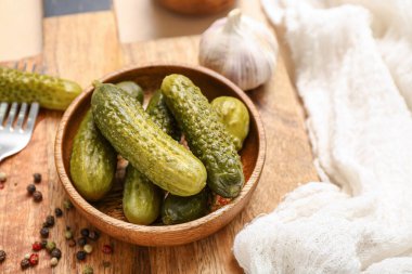 Bej arka planda mayalanmış salatalıklı kase.