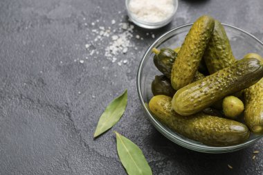 Lezzetli mayalanmış salatalıklı kase ve koyu grunge arka planda malzemeler.