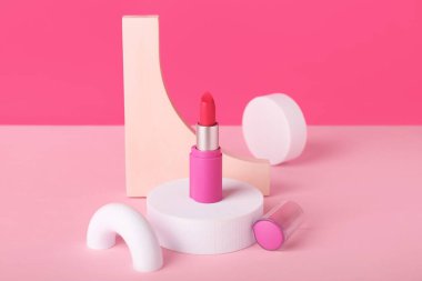 Pembe arka planda dekoratif alçı podyumlar ve ruj.