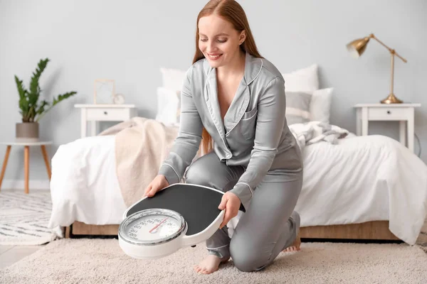 Young Overweight Woman Putting Scales Floor Bedroom — Stock Photo, Image
