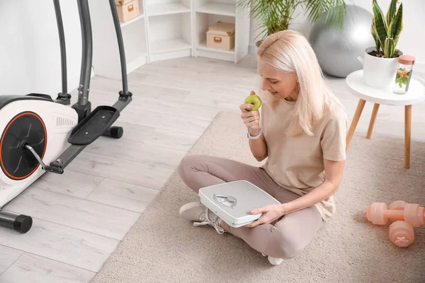 Sporty Mature Woman Apple Scales Sitting Home — Stock Photo, Image