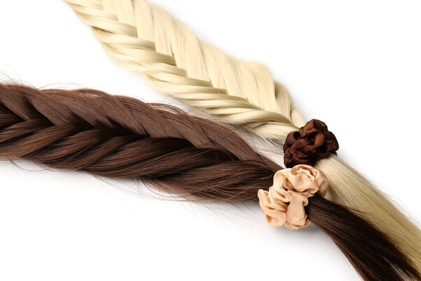 Braided strands with scrunchies on white background, closeup