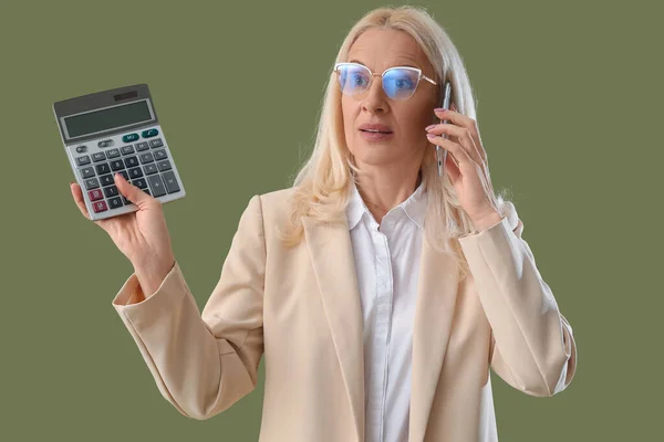 Gammal Kvinna Med Miniräknare Talar Med Mobiltelefon Grön Bakgrund — Stockfoto