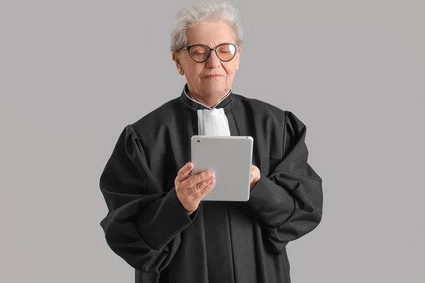 Kıdemli Yargıç Gri Arkaplanda Tablet Bilgisayar Kullanıyor — Stok fotoğraf