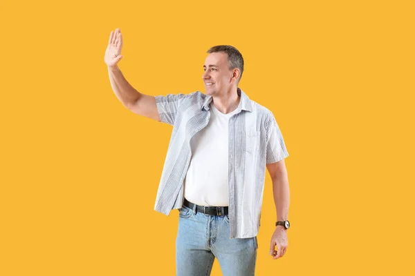 Volwassen Man Zwaaiend Met Hand Een Gele Achtergrond Hallo Concept — Stockfoto