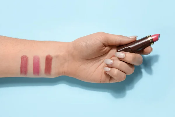 stock image Woman with lipstick and samples on blue background