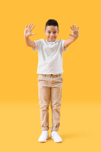 Μικρό Αφροαμερικανό Αγόρι Που Κουνάει Χέρια Του Κίτρινο Φόντο — Φωτογραφία Αρχείου