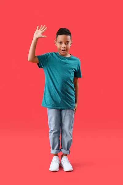 Μικρό Αφροαμερικανό Αγόρι Που Κουνάει Χέρι Του Κόκκινο Φόντο — Φωτογραφία Αρχείου