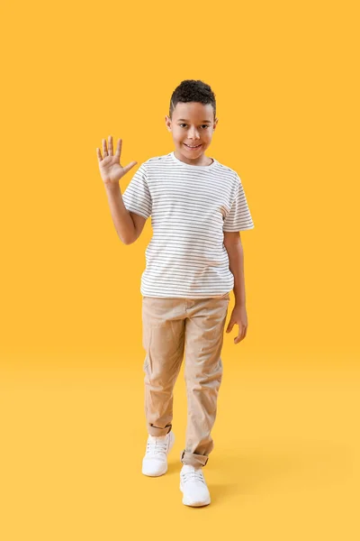 Μικρό Αφροαμερικανό Αγόρι Που Κουνάει Χέρι Του Κίτρινο Φόντο — Φωτογραφία Αρχείου