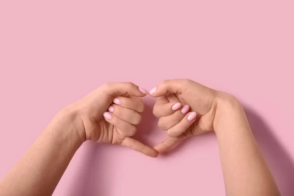 Kobieta Robi Serce Rękami Różowym Tle — Zdjęcie stockowe