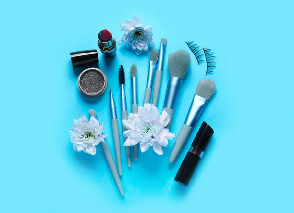 Dekorative Kosmetik Mit Pinseln Und Blumen Auf Blauem Hintergrund — Stockfoto