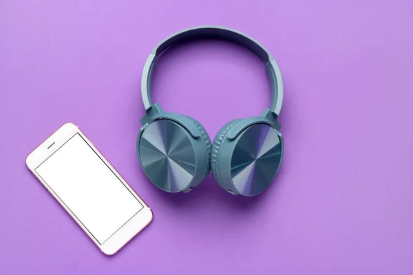 带紫色背景手机的耳机 — 图库照片