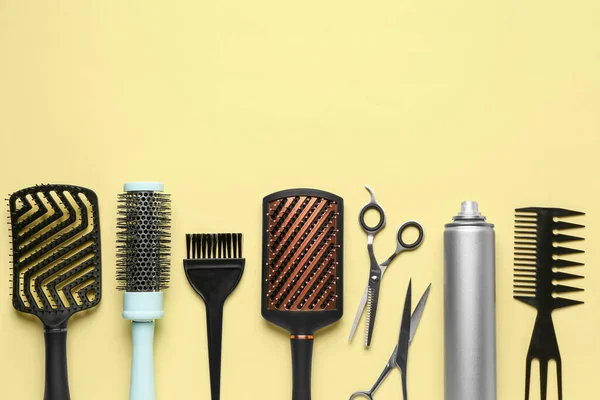 Hairdresser\'s brushes with spray and scissors on yellow background