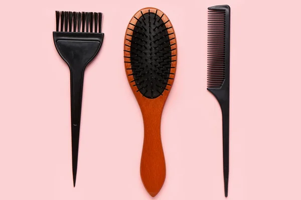 Hairdresser\'s brushes on pink background