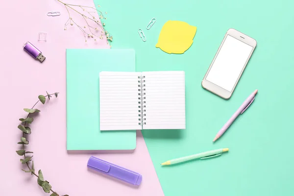 Composition with notebook, mobile phone and pens on colorful background