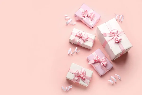 粉色背景上有漂亮弓形和蛇形的礼品盒 — 图库照片