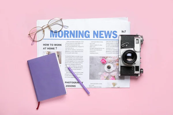 带照相相机 笔记本和粉色背景眼镜的报纸 — 图库照片