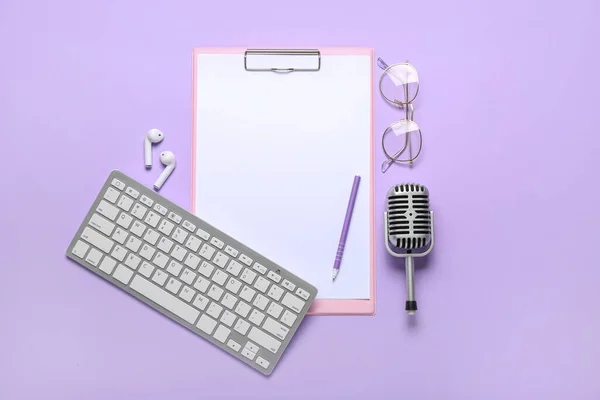 Clipboard with earphones, microphone, eyeglasses and computer keyboard on lilac background