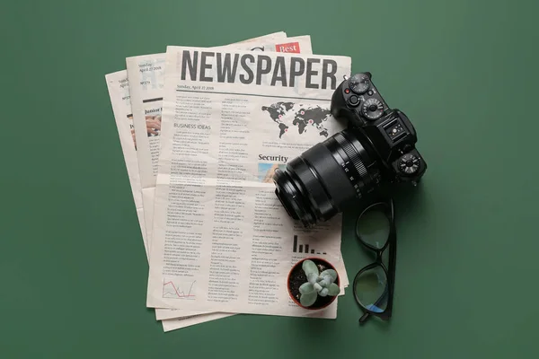 Noviny Fotoaparátem Brýlemi Květináčem Zeleném Pozadí — Stock fotografie