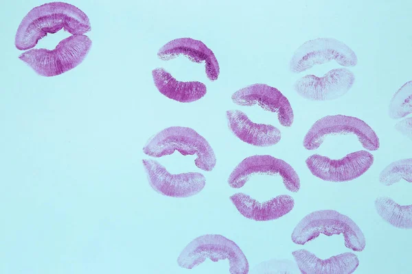 Purple lipstick kiss marks on blue background