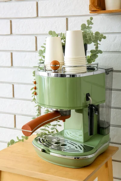 Moderne Kaffeemaschine Mit Pappbechern Und Zimmerpflanze Auf Tisch Nahe Weißer — Stockfoto