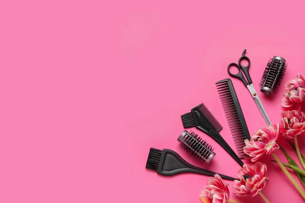 Composition with hairdresser tools and tulip flowers on pink background