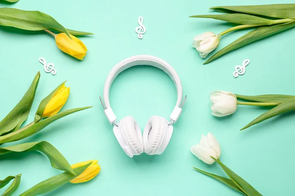 stock image Composition with modern headphones and beautiful tulip flowers on color background