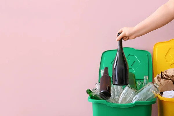 ピンクの壁の近くのゴミ箱にゴミを投げ込む女性 リサイクルコンセプト — ストック写真