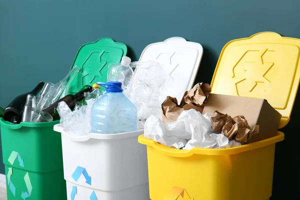 リサイクルシンボルと緑の壁の近くに別のゴミとゴミ箱 — ストック写真