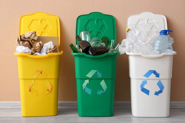 Δοχεία Απορριμμάτων Σύμβολο Ανακύκλωσης Και Διάφορα Σκουπίδια Κοντά Μπεζ Τοίχο — Φωτογραφία Αρχείου