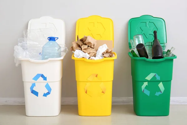白い壁の近くのリサイクルのシンボルと異なるゴミとゴミ箱 — ストック写真