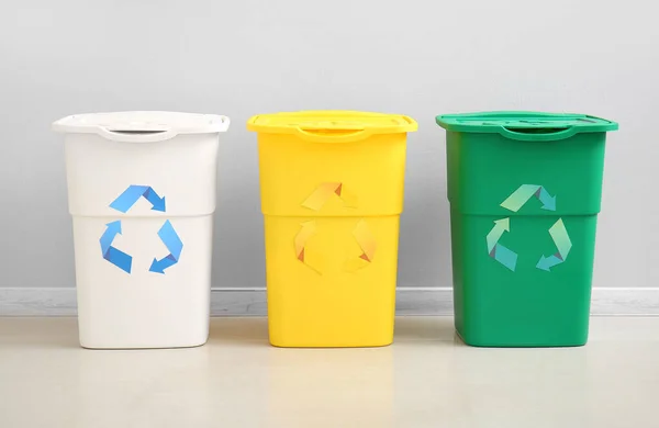 Różne Pojemniki Śmieci Symbolem Recyklingu Pobliżu Białej Ściany — Zdjęcie stockowe