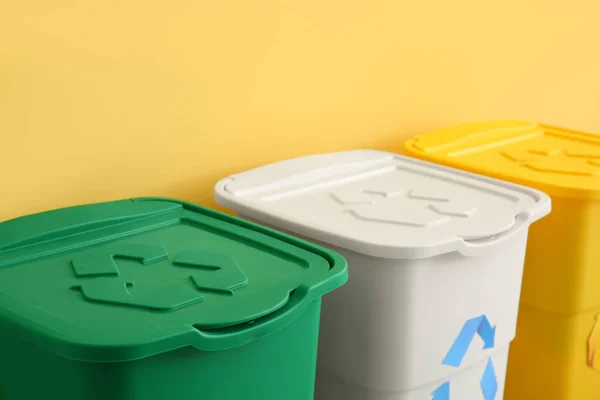 Diferentes Lixeiras Com Símbolo Reciclagem Perto Parede Amarela — Fotografia de Stock