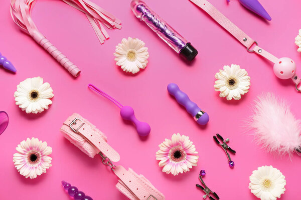 Секс-игрушки с цветами на розовом фоне