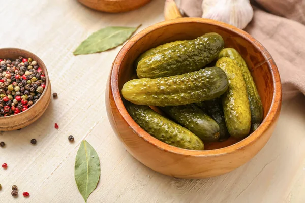 stock image Bowl with tasty fermented cucumbers on light wooden background